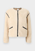 Beige Jacke aus Kunstpelz mit rundem Ausschnitt, Frontreißverschluss, schwarzen Akzenten an den Seiten und zwei Seitentaschen. Weiches, strukturiertes Material.