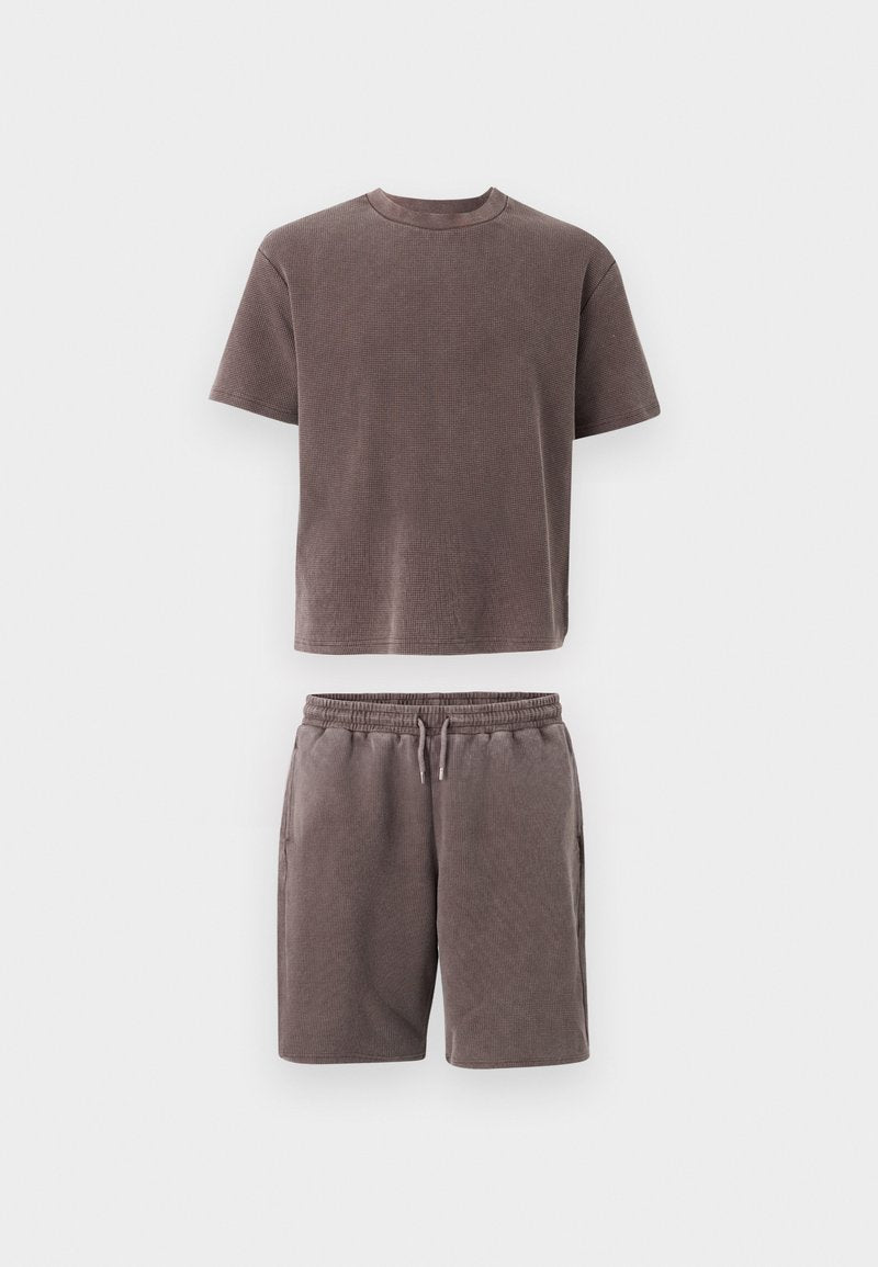 Braunes, strukturiertes T-Shirt mit kurzen Ärmeln und Rundhalsausschnitt, kombiniert mit passenden Shorts mit Kordelzug, flach auf weißem Hintergrund dargestellt.