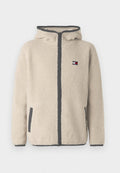 Beige Fleecejacke mit Reißverschluss, Kapuze und grauen Akzenten. Verfügt über seitliche Taschen und ein kleines Logo-Patch auf der Brust. Weiche Textur.