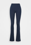 Marineblaue ausgestellte Leggings aus einem weichen, dehnbaren Stoff mit glatter Textur. Sie verfügen über einen breiten elastischen Bund und ein dezentes Markenlogo.