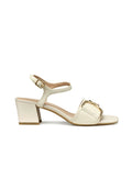 Block-heeled Sandalen aus cremefarbenem Leder mit einem breiten, quadratischen Zehenriemen, der mit einer goldenen Schnalle akzentuiert ist. Knöchelriemen mit verstellbarer Schnalle.
