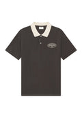 Dunkelbraunes Poloshirt mit kurzen Ärmeln, kontrastierendem off-white Kragen, Zweiknopfleiste und kleinem weißen Logo auf der linken Brust.