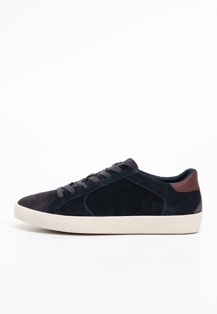 Marineblaue Wildledersneaker mit einer cremefarbenen Gummisohle, runder Zehenform und einer dunkelbraunen Ferseneinlage. Verfügt über flache Schnürsenkel und dezente Nähte.