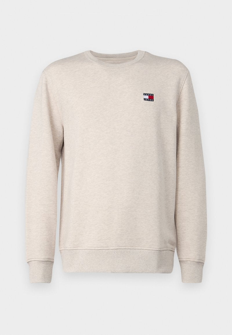 Hellbeige Sweatshirt aus Baumwolle, mit Rundhalsausschnitt, gerippten Manschetten und einem kleinen Logo-Patch auf der Brust mit roten und blauen Elementen.
