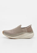 Beige Strick-Sneaker zum Hineinschlüpfen mit dicker weißer Sohle, beschriftet mit "ARCH FIT" und "MAX CUSHION", mit rundem Zehenbereich und flexiblem Obermaterial.