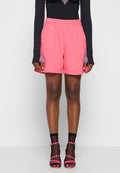 Rosa Baumwollshorts mit einem elastischen Bund und Seitentaschen; kombiniert mit einem Langarmoberteil aus strukturiertem schwarzem Stoff mit lila Akzenten.