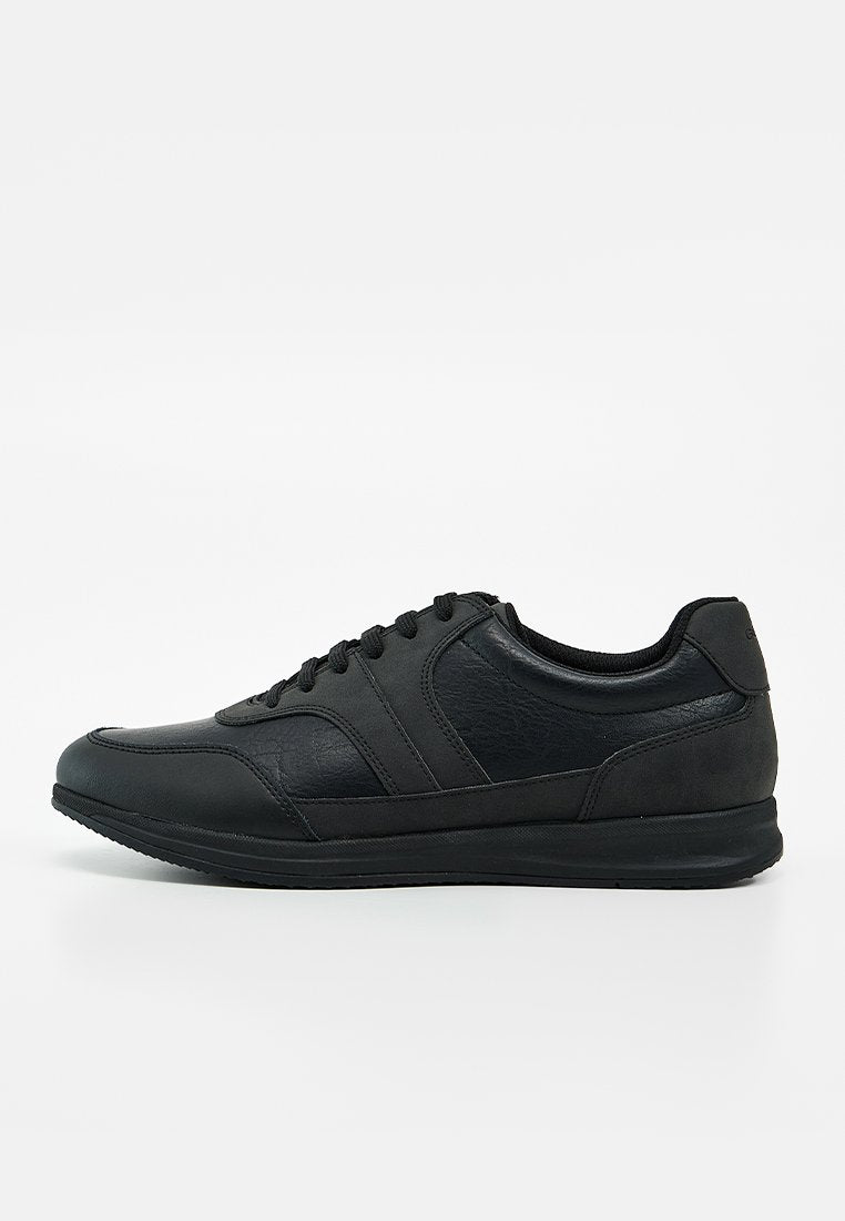 Schwarzer Low-Top-Sneaker mit Schnürverschluss, strukturiertem Leder-Obermaterial und Gummisohle auf schlichtem weißen Hintergrund.