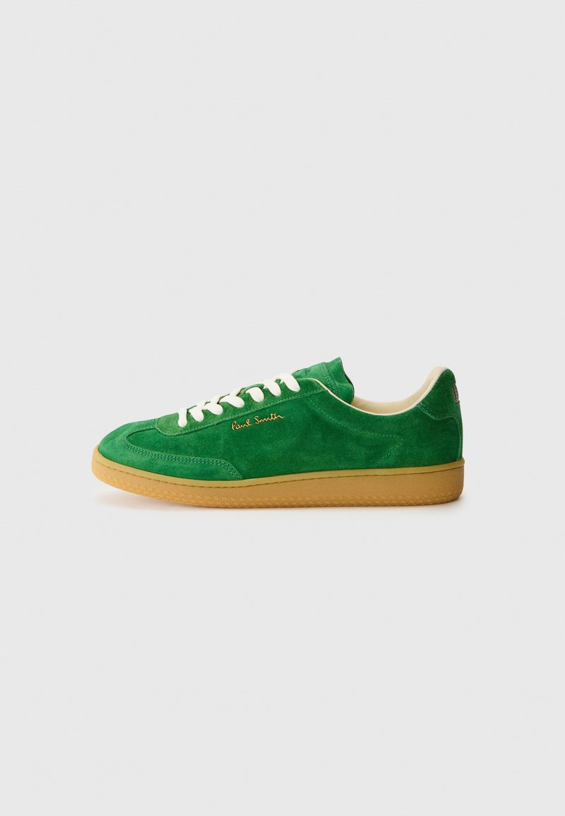 Grüne Wildledersneaker mit einer Gummisohle, weißen Schnürsenkeln und goldener Markenkennzeichnung an der Seite. Glatte Textur mit ausgeprägten Steppdetails.