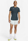 Männliches Sportoutfit mit einem dunkelgrünen Kurzarmshirt mit Nike-Logo und hellmintfarbenen Shorts, beide aus leichtem Material.