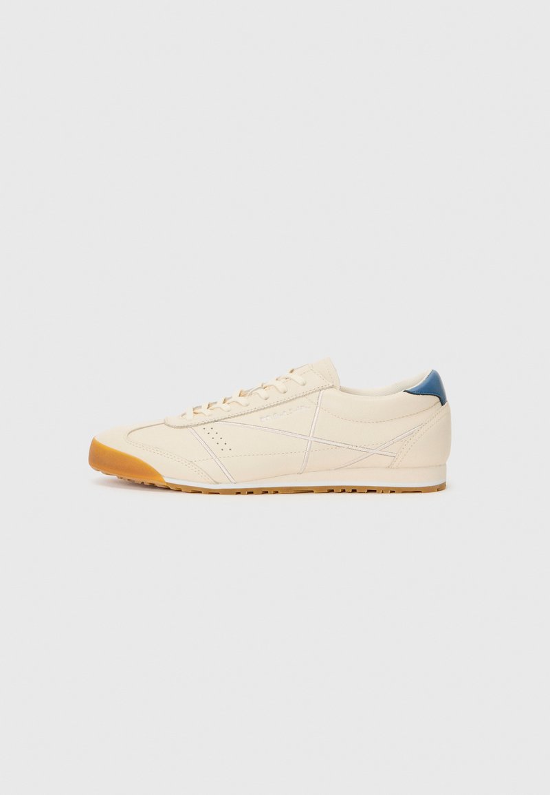 Cremfarbene Sneaker mit einem glatten Obermaterial aus Leder, kontrastierendem blauen Fersenakzent und einer Gummisohle mit strukturiertem Grip-Muster.