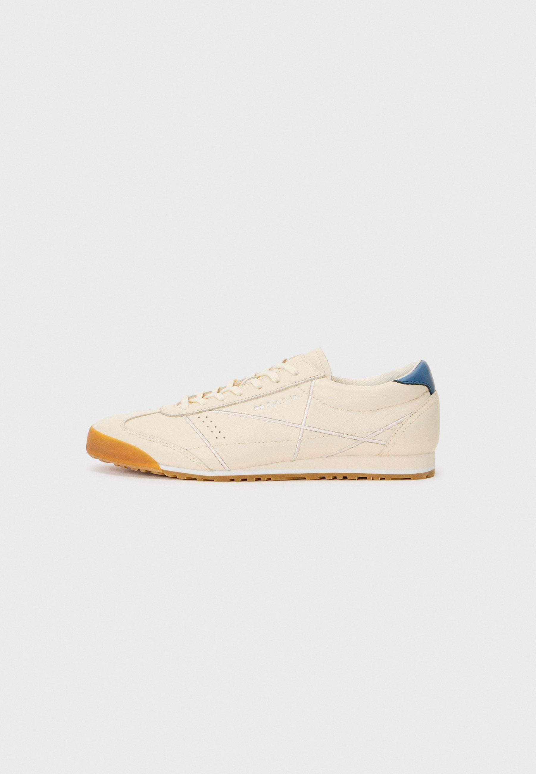 Cremfarbene Sneaker mit einem glatten Obermaterial aus Leder, kontrastierendem blauen Fersenakzent und einer Gummisohle mit strukturiertem Grip-Muster.