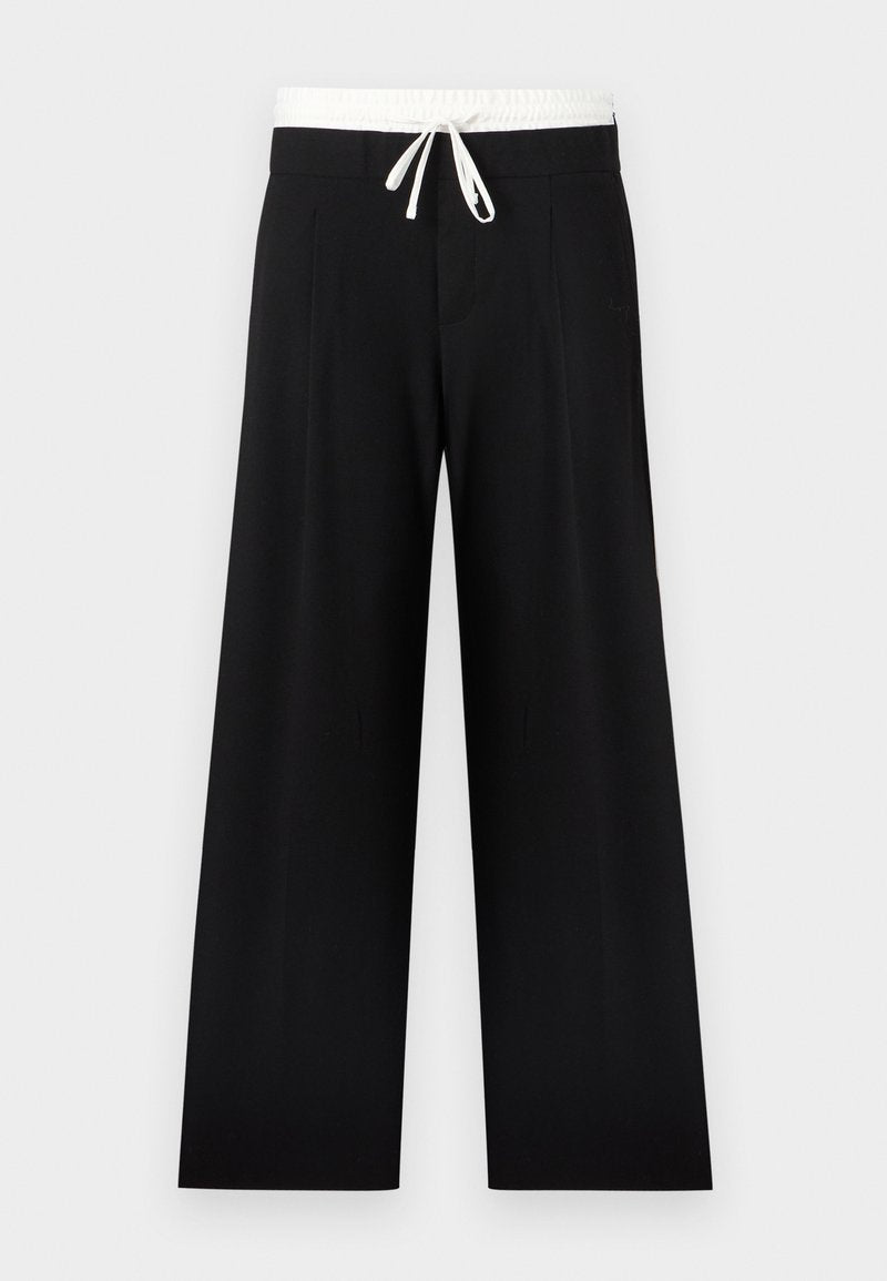 Schwarze Hosen mit weitem Bein, weißem elastischem Bund und Kordelzug, vorne mit Falten und glatter Textur.