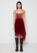 Samtrotes Kleid mit verstellbaren Spaghettiträgern, geschichtetem Design und Rüschendetails am Saum, kombiniert mit kniehohen braunen Stiefeln.