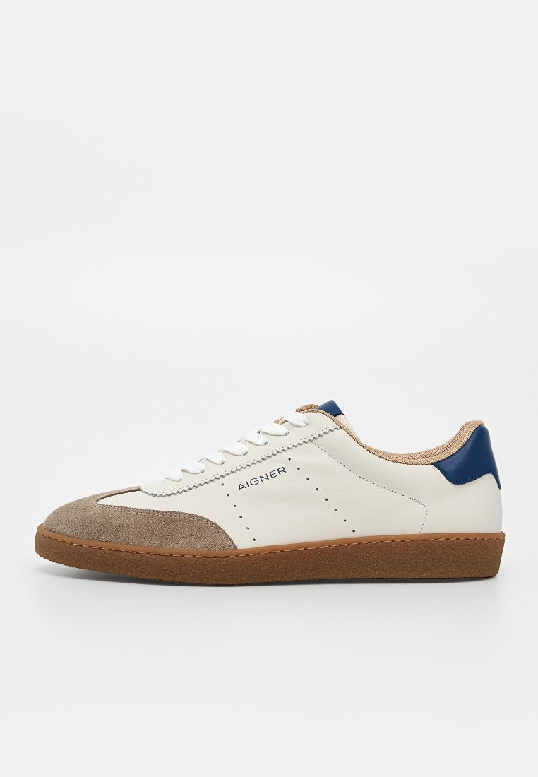 Weißer und beiger Ledersneaker mit brauner Gummisohle, blauem Fersenakzent, weißen Schnürsenkeln und "AIGNER"-Branding an der Seite.