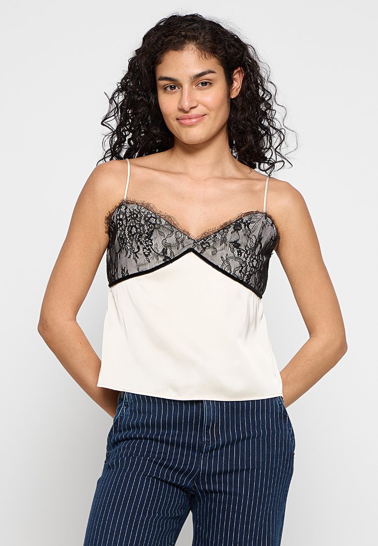 Cami-Top mit einem schwarzen Spitzenoverlay, verstellbaren Trägern, einem V-Ausschnitt und einem cremfarbenen Grundton. Glatte Textur und lockere Passform.
