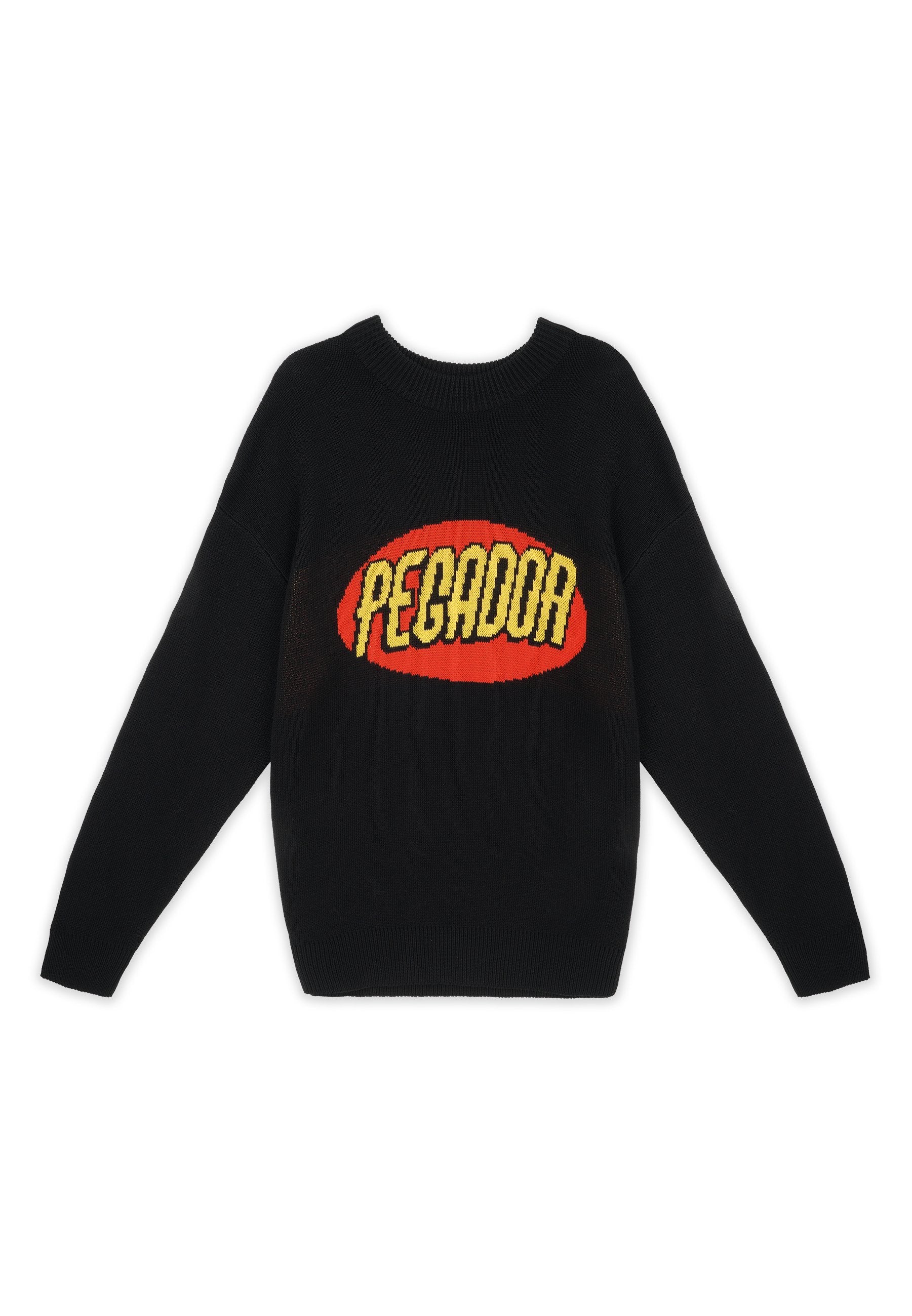 Schwarzer Strickpullover mit einem großen roten ovalen Grafikdesign und dem Text "PECADOR" in Gelb, langen Ärmeln und geripptem Rundhalsausschnitt.