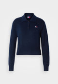 Marineblauer Poloshirt-Pullover aus weichem Material mit langen Ärmeln, einem Kragen, drei Knöpfen und einem kleinen Logo-Patch auf der Brust.