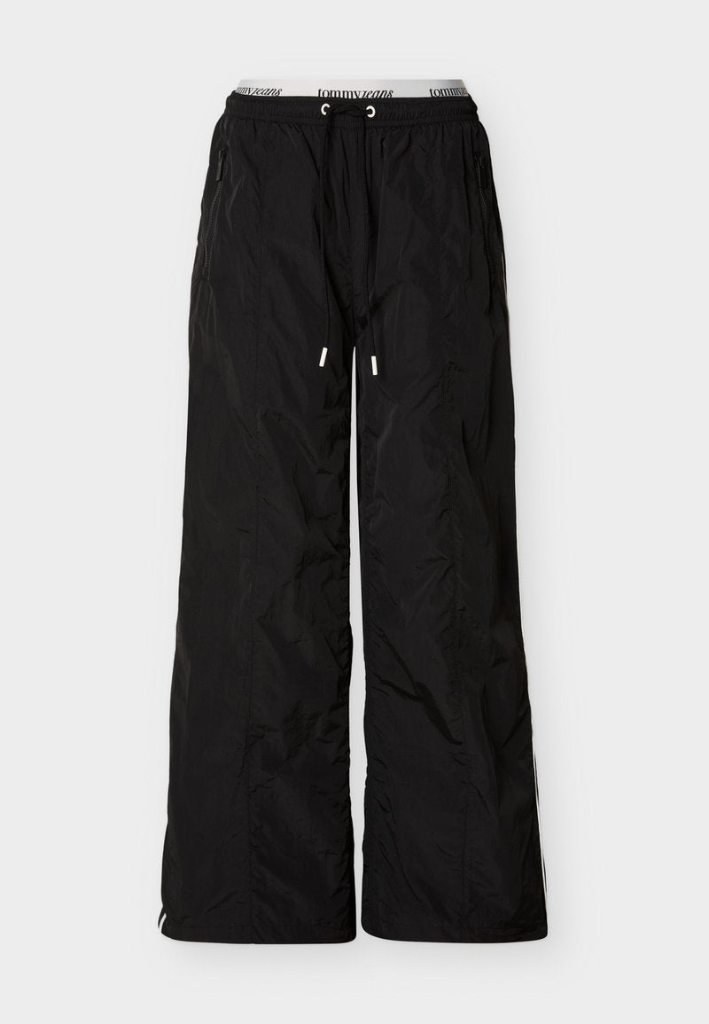 Schwarze, locker sitzende Nylonhose mit elastischem Bund und Kordelzug, seitlichen Reißverschlusstaschen und sichtbarem Tommy Jeans Marken-Innenbund.