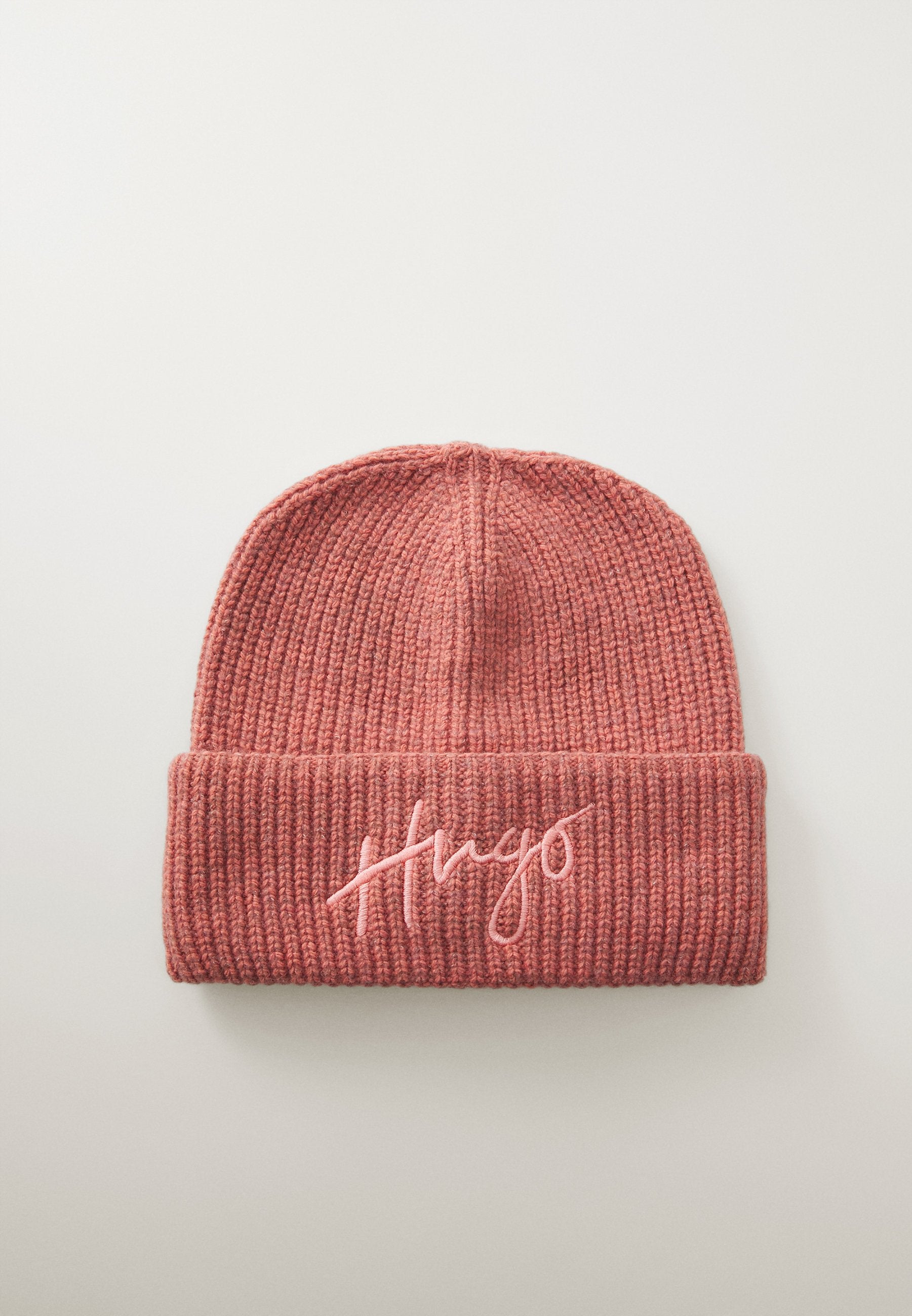 Strickmütze in zartem, rosafarbenem Ton mit geripptem Muster und umgeschlagenem Saum, ausgestattet mit gesticktem "Hugo" in hellerem rosa Faden.