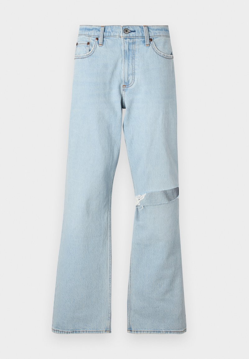 Hellblaue Jeans im Flared-Design mit einem ausgefransten Patch am Knie und normalen Fronttaschen.