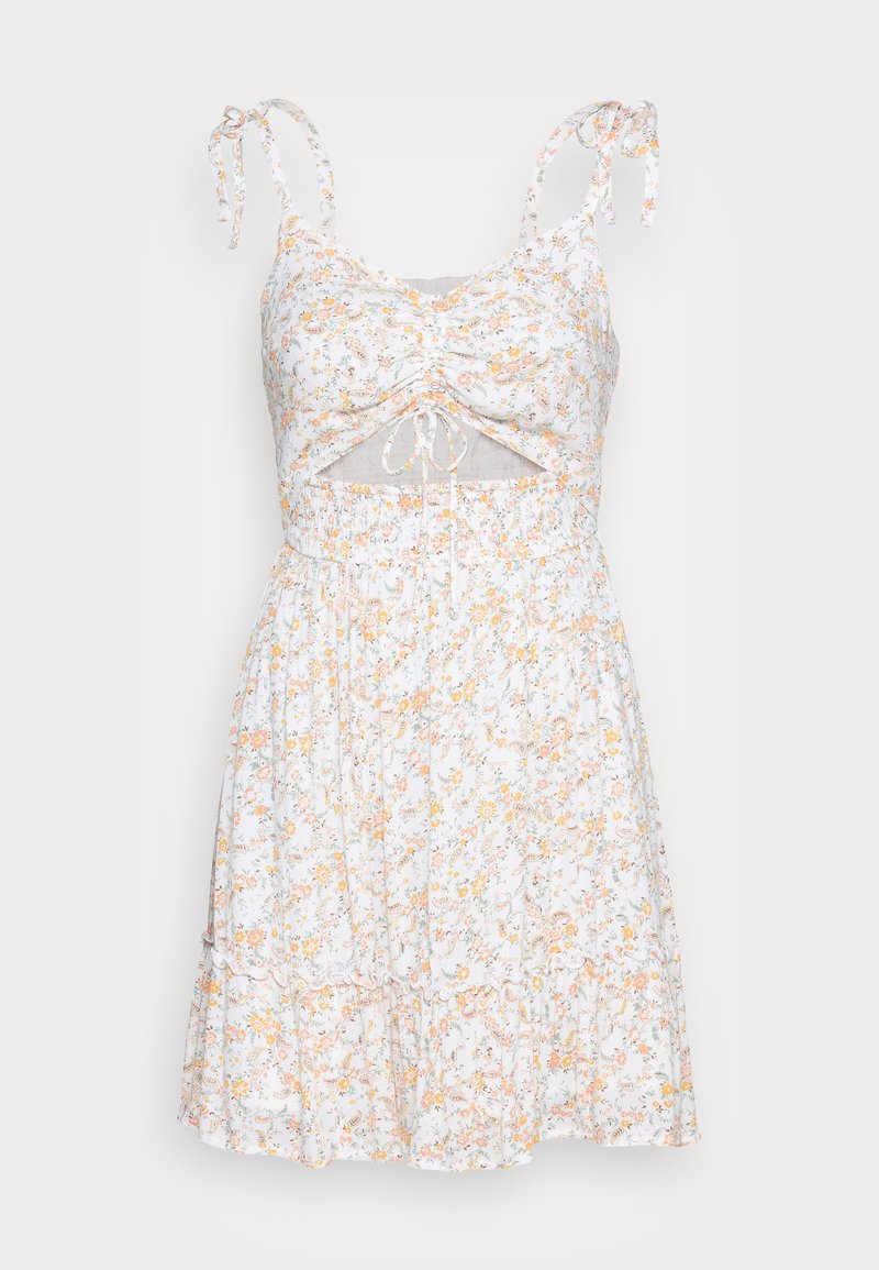 Weißes Blumen Kleid mit orangefarbenen und grünen Mustern, verstellbaren Bindeschlaufen und gerafftem Taillenbereich, das einen ausgeschnittenen Mittelteil und einen rüschengesäumten Saum aufweist.