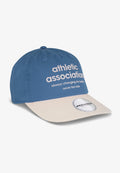 Blaues Baseballcap mit beige-farbenem Schirm. Mit weißem Text: "Athletic Association immer im Wandel zum Besseren, niemals zu spät" und einem runden Logo.