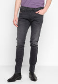Dunkelgraue Denim-Jeans im Slim-Fit, mit Reißverschluss, fünf Taschen und dezenten Ausbleichungen. Getragen mit schwarzen Knöchelstiefeln.