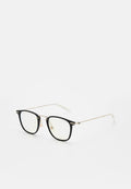 Schwarze, quadratische Brille mit goldfarbenen Metallakzenten, dünnen Bügeln und transparenten Gläsern. Mit Nasenpads für Komfort ausgestattet.