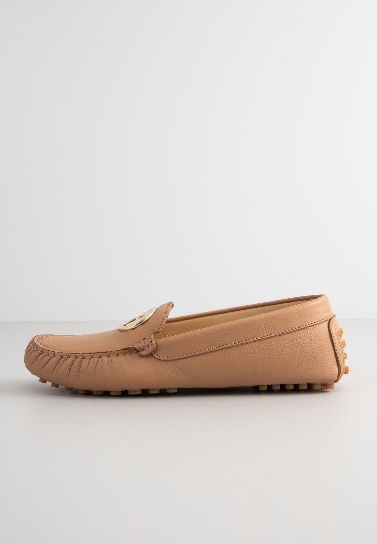 Beige Leder Slipper mit genähter Spitze, goldenen Hardwareakzenten und gummierter, genoppter Sohle. Glatte Textur, niedriges Profil-Design.