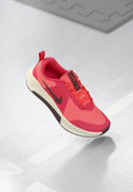 Rosa Sportschuh mit einem Mesh-Obermaterial, kontrastierenden dunklen Akzenten und einer dicken weißen Zwischensohle. Verfügt über eine abgerundete Zehenpartie und eine strukturierte Sohle.