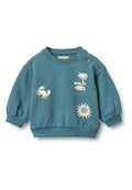 Türkisfarbener Kinderpullover mit cremefarbenen Grafiken: Krabbe, Palme, Sonne und dem Text "WHEAT." Mit Knopfdetail an der Schulter.