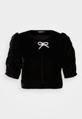 Schwarze Samt-Cropped-Jacke mit kurzen Puffärmeln, featuring einem metallischen Schleifendetail an der Vorderseite und einem runden Ausschnitt.