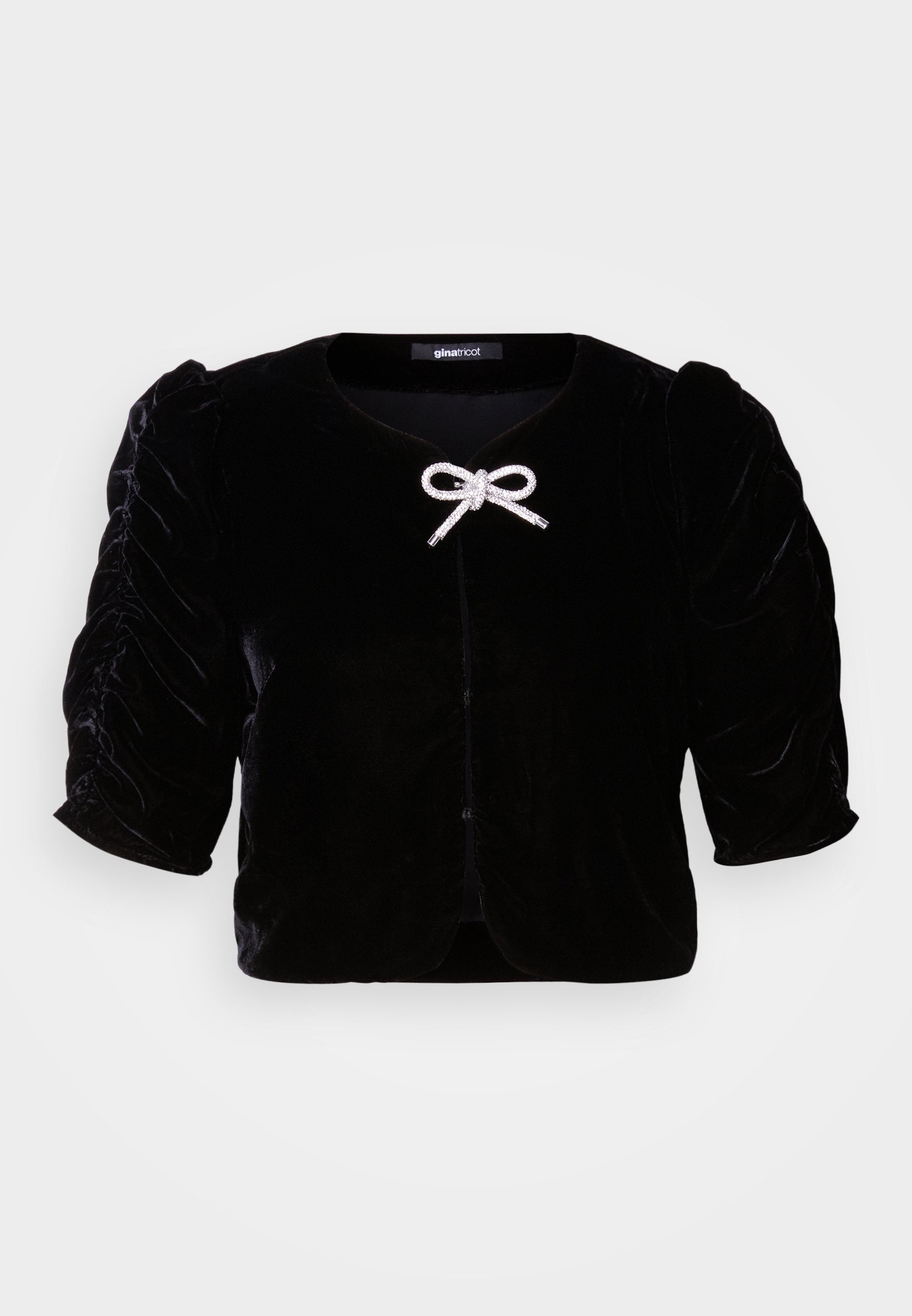 Schwarze Samt-Cropped-Jacke mit kurzen Puffärmeln, featuring einem metallischen Schleifendetail an der Vorderseite und einem runden Ausschnitt.