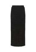 Schwarze Midikleider mit einem strukturierten Zickzackmuster. Elastischer Taillenbund und eine schmale Silhouette, mit einem durchsichtigen unteren Teil.