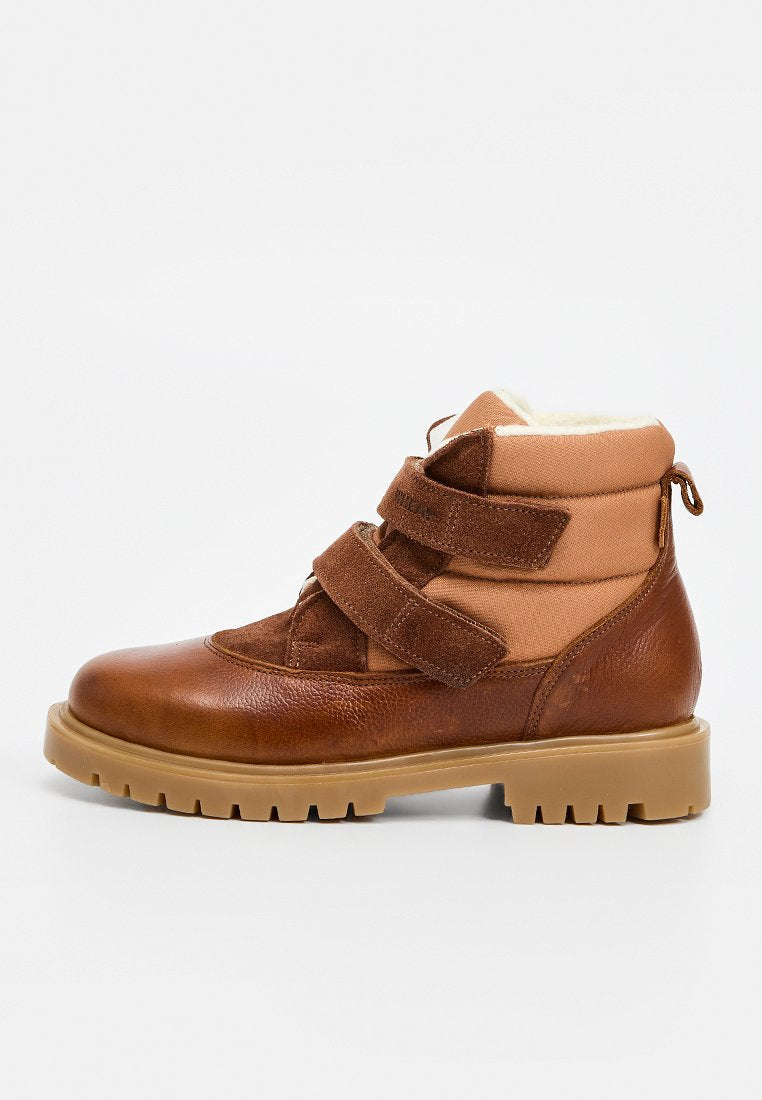 Brauner Leder-Stiefel bis zum Knöchel mit beigefarbenen Textilakzenten, ausgestattet mit zwei Klettverschlüssen, einem gepolsterten Schaft und einer Gummisohle mit Riffelprofil.