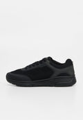 Schwarzer Sneaker mit niedrigem Schaft, Mesh- und synthetischem Obermaterial, Schnürverschluss und dicker Gummisohle, seitlich auf weißem Hintergrund dargestellt.