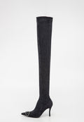 Schwarze, knöchelhohe Stiletto-Stiefel mit spitzer Zehe, schlankem hohen Absatz und silberner dekorativer Schnalle an der Zehe vor weißem Hintergrund.