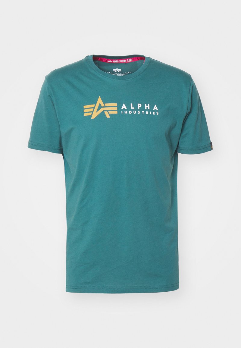 Türkises Baumwoll-T-Shirt mit kurzen Ärmeln. Mit goldenem Logo und dem Text "ALPHA INDUSTRIES" auf der Vorderseite. Klassischer Rundhalsausschnitt.