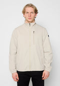 Hellbeige Jacke mit hohem Kragen, Reißverschluss vorne und Reißverschlusstasche auf der Brust. Hergestellt aus glattem Stoff mit elastischen Bündchen und Saum.