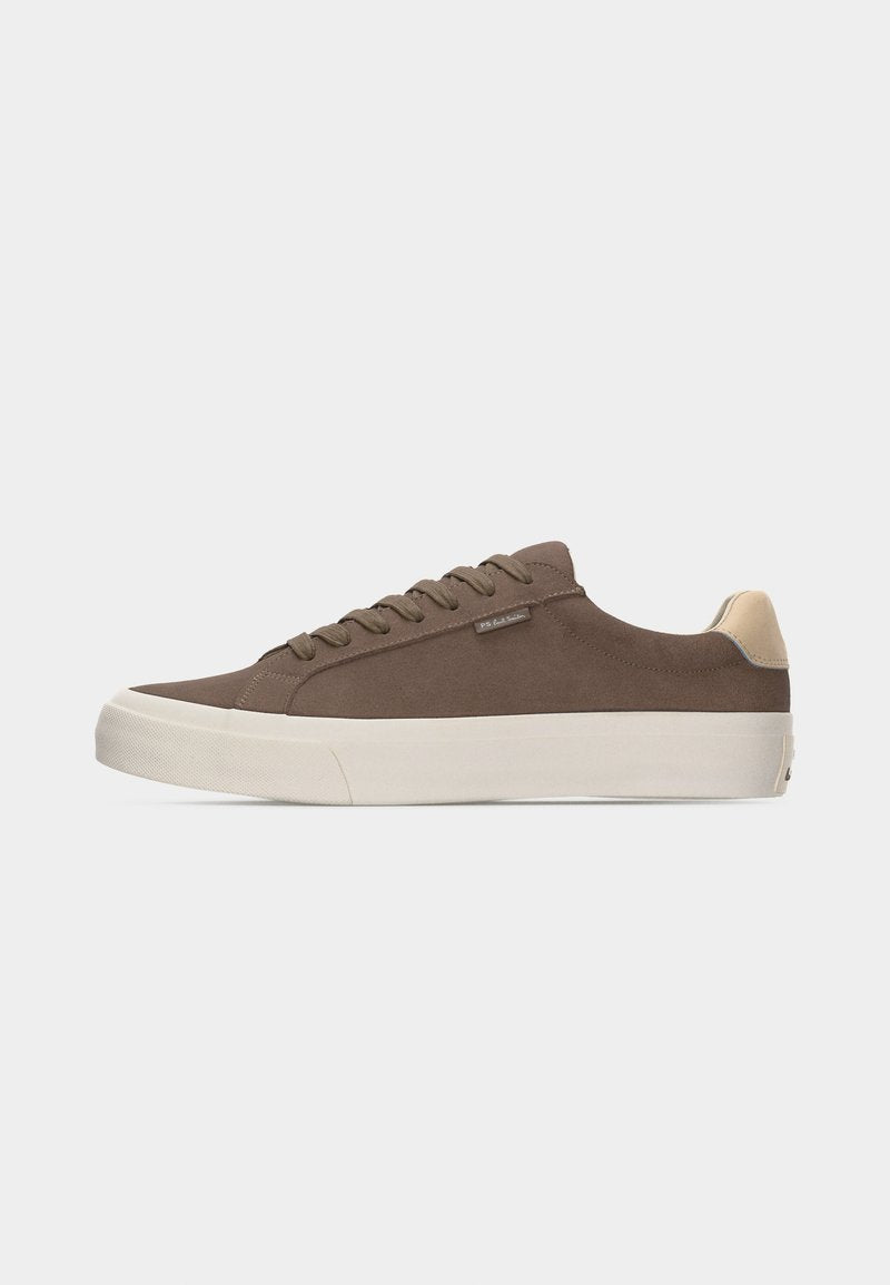 Brauner Sneaker mit niedrigem Schaft, beigem Fersenlaschen, weißer dicker Sohle und passenden braunen Schnürsenkeln vor einfarbigem Hintergrund.