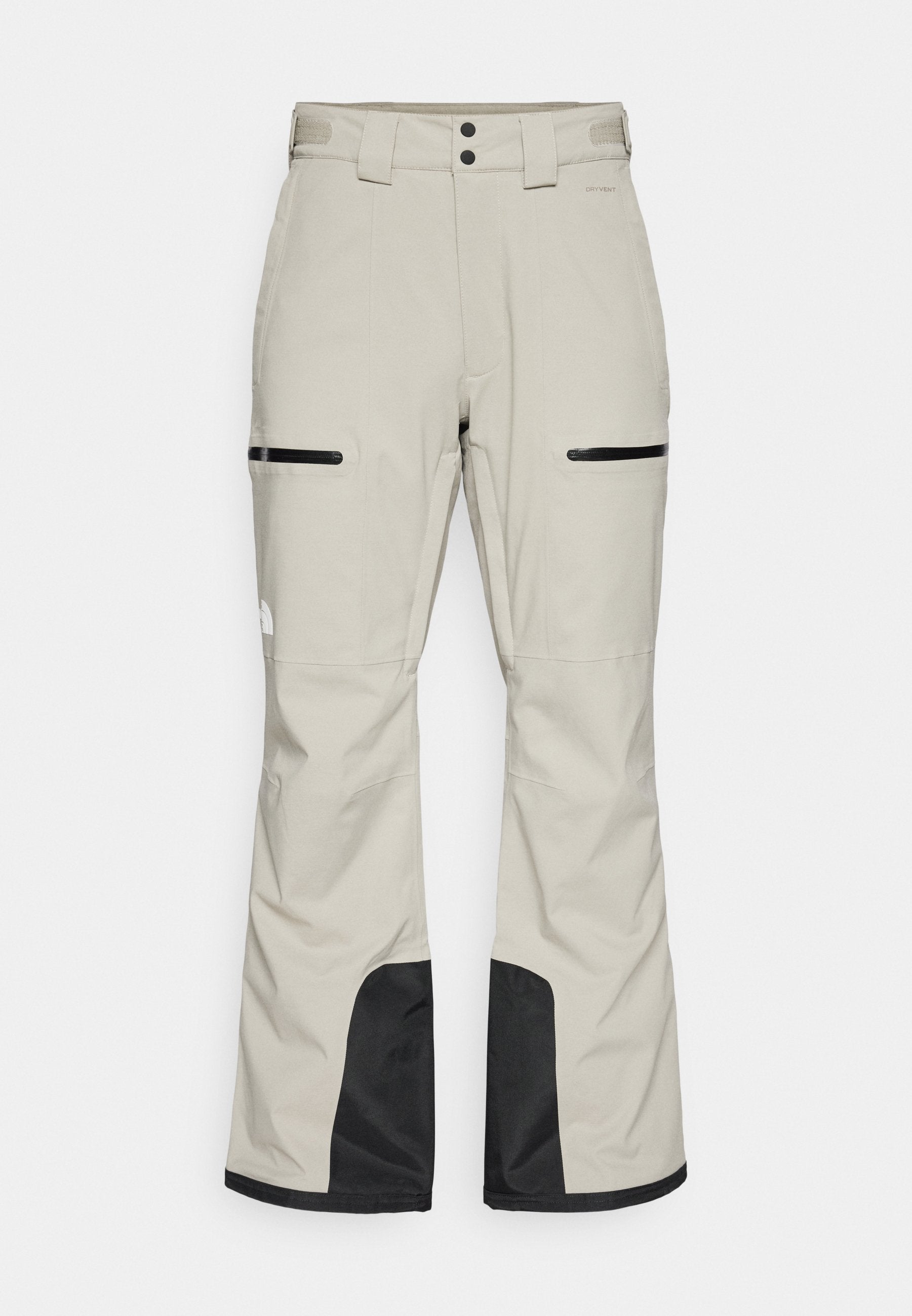 Helle beige Schneehosen mit schwarzen Akzenten, ausgestattet mit einem verstellbaren Taillenbund, zwei seitlichen Taschen mit Reißverschlüssen und verstärkten schwarzen Unterbeinen.