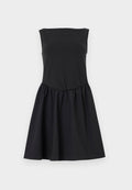 Ärmelloses schwarzes Kleid mit gerade verlaufendem Ausschnitt und geraffter Taille, das in einen Rock über dem Knie ausläuft, vor neutralem Hintergrund präsentiert.