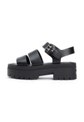 Schwarze Plateau-Sandalen mit drei breiten Riemen, einem verstellbaren Knöchelriemen und einer strukturierten Sohle mit Zickzackmuster.