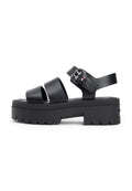 Schwarze Plateau-Sandalen mit drei breiten Riemen, einem verstellbaren Knöchelriemen und einer strukturierten Sohle mit Zickzackmuster.