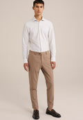 Weiße gestreifte Hemdbluse, beige maßgeschneiderte Hose, dunkle Schuhe. Schlankes Design mit Knopfverschluss und langen Ärmeln. Glatte Stoffoberfläche.