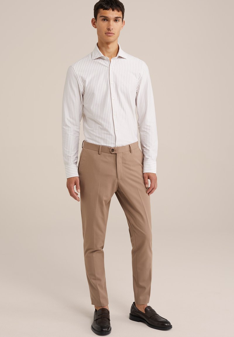 Weiße gestreifte Hemdbluse, beige maßgeschneiderte Hose, dunkle Schuhe. Schlankes Design mit Knopfverschluss und langen Ärmeln. Glatte Stoffoberfläche.