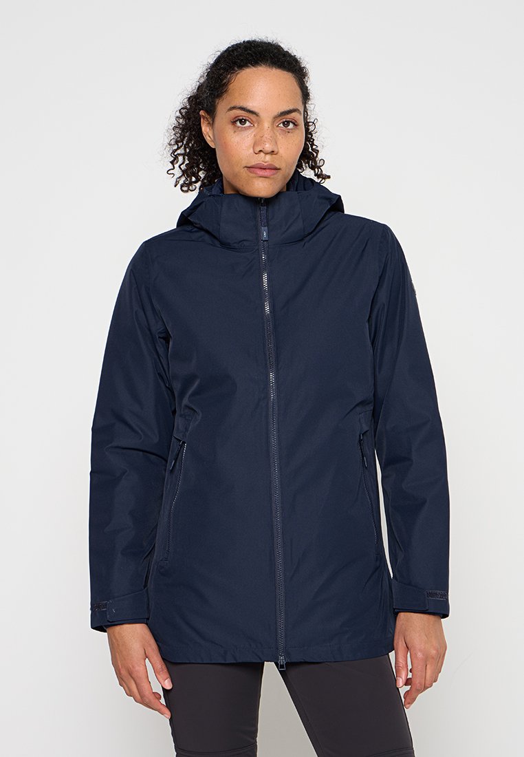 Marineblauer wasserdichter Anorak aus glattem Nylon mit Frontreißverschluss, verstellbarer Kapuze und Taschen auf beiden Seiten. Verfügt über einen etwas längeren Schnitt.