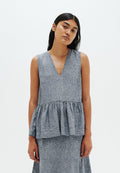 Grauer Peplum-Top aus leichtem Stoff mit tiefem V-Ausschnitt und geraffter Taille, das eine weiche Textur und klare Linien aufweist.