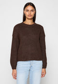 Brauner Strickpullover mit Rundhalsausschnitt und langen Ärmeln, mit strukturierter Oberfläche und leicht cropped Saum, kombiniert mit hellen Jeans.