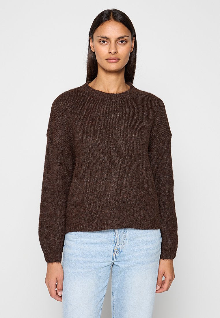 Brauner Strickpullover mit Rundhalsausschnitt und langen Ärmeln, mit strukturierter Oberfläche und leicht cropped Saum, kombiniert mit hellen Jeans.